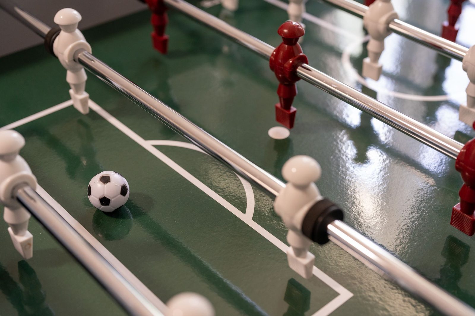 A foosball game with a soccer ball on the field