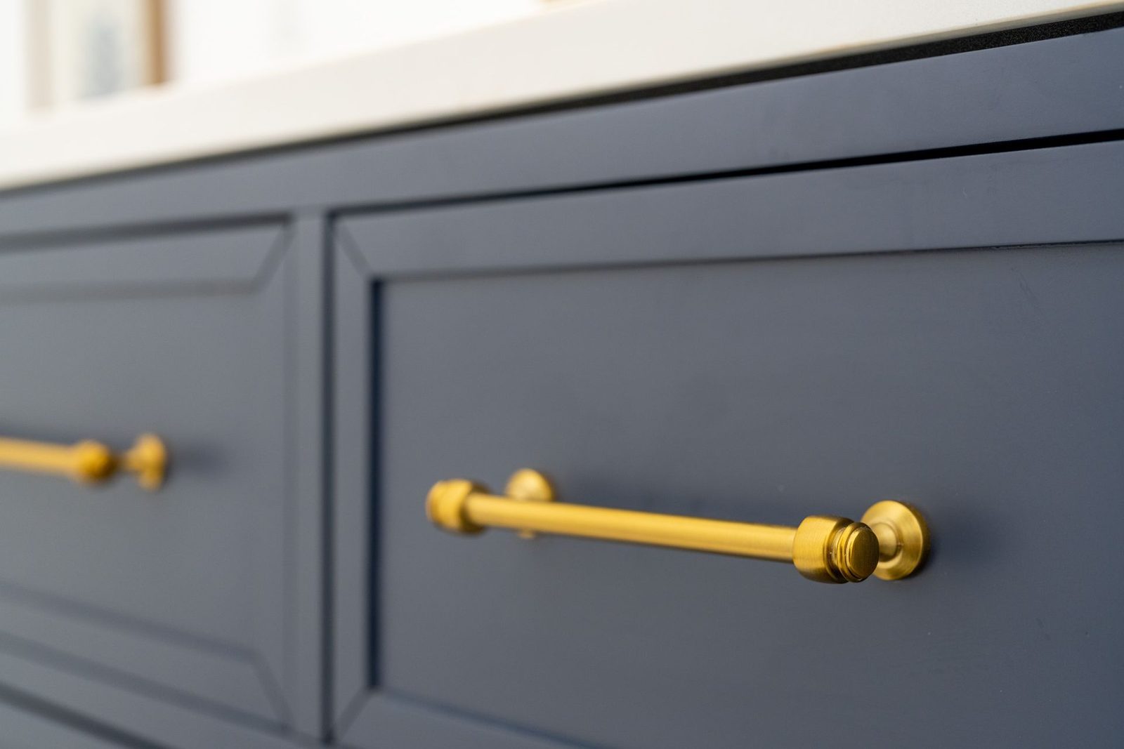A close up of a blue cabinet with gold handles.