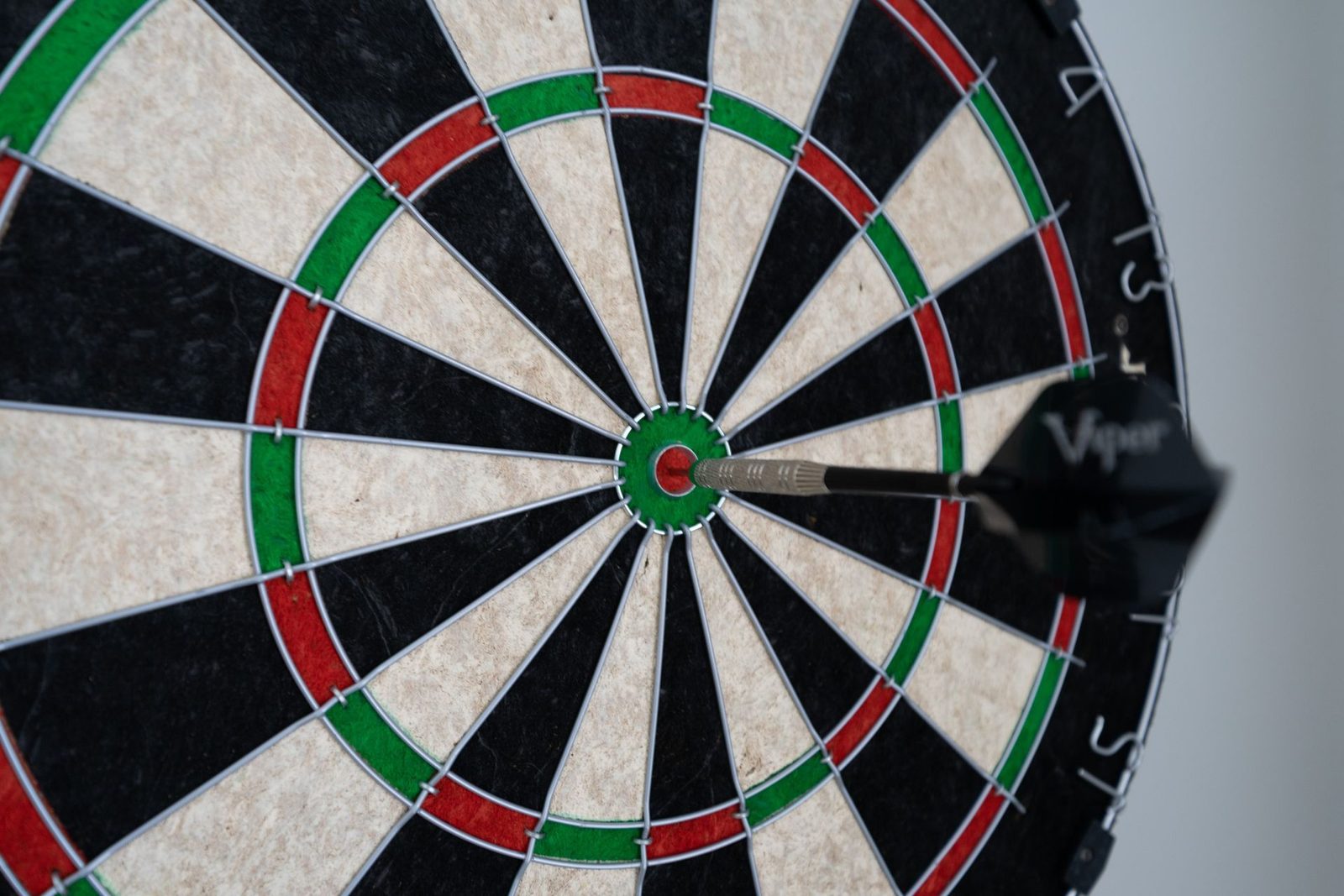 A close up of a dart board with a dart in the center