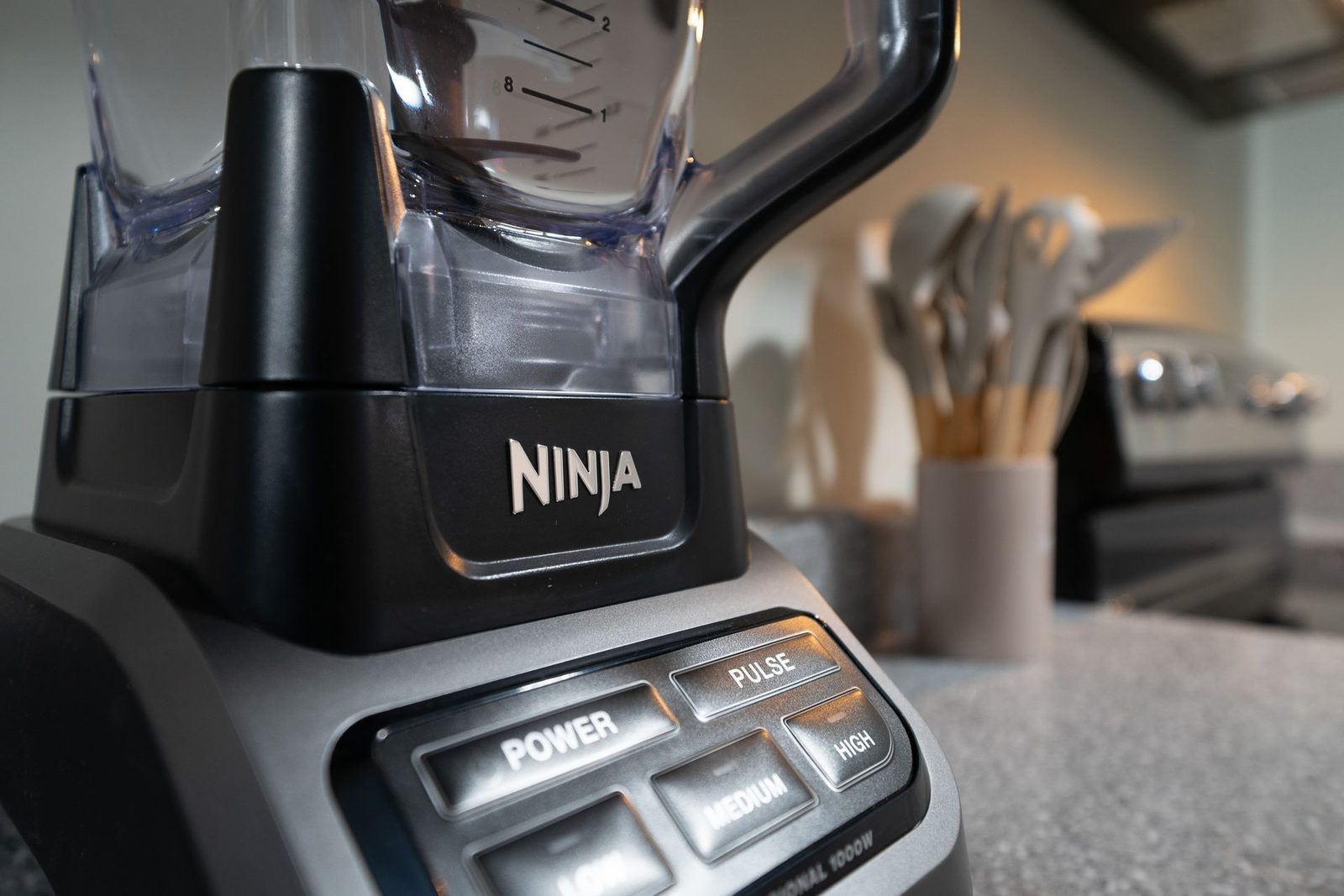 A ninja blender is sitting on a counter in a kitchen.