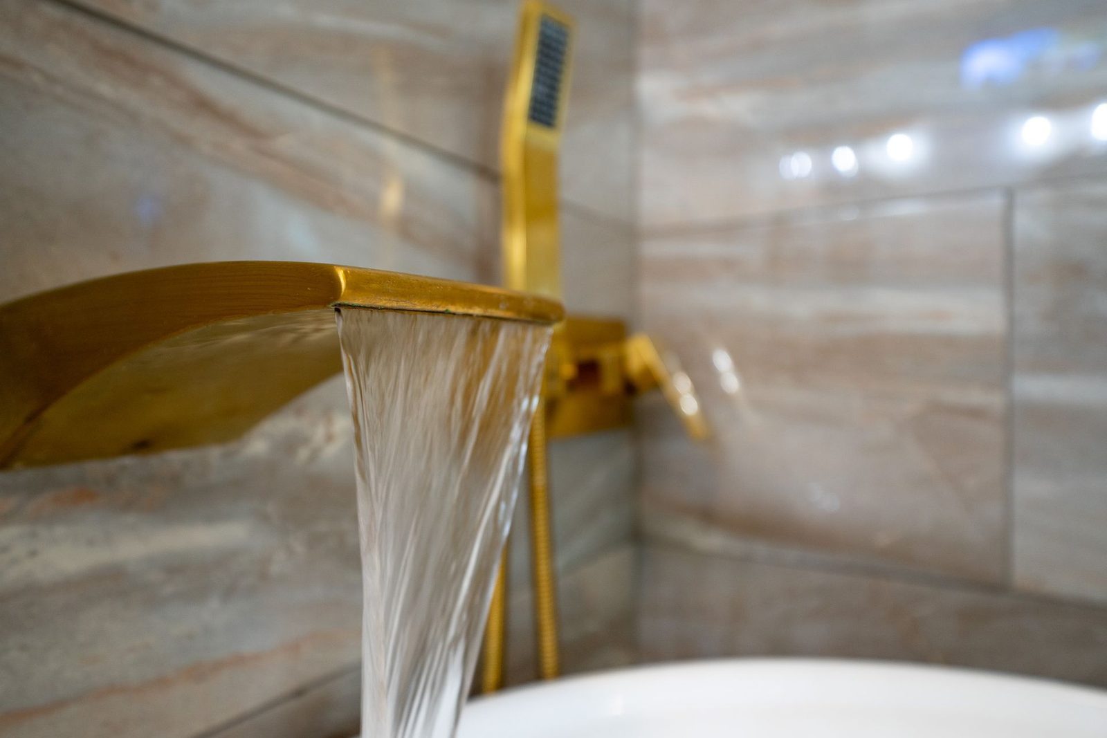 A close up of a waterfall faucet in a bathroom.
