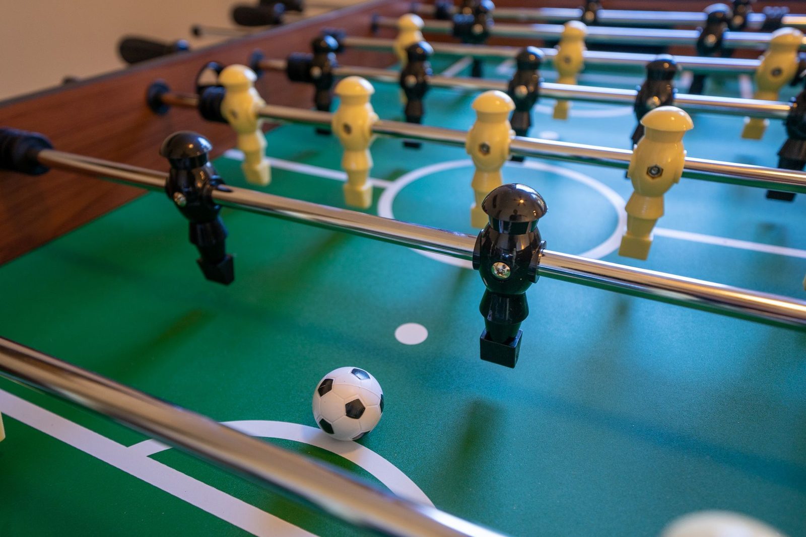 A foosball game with a soccer ball on the field.