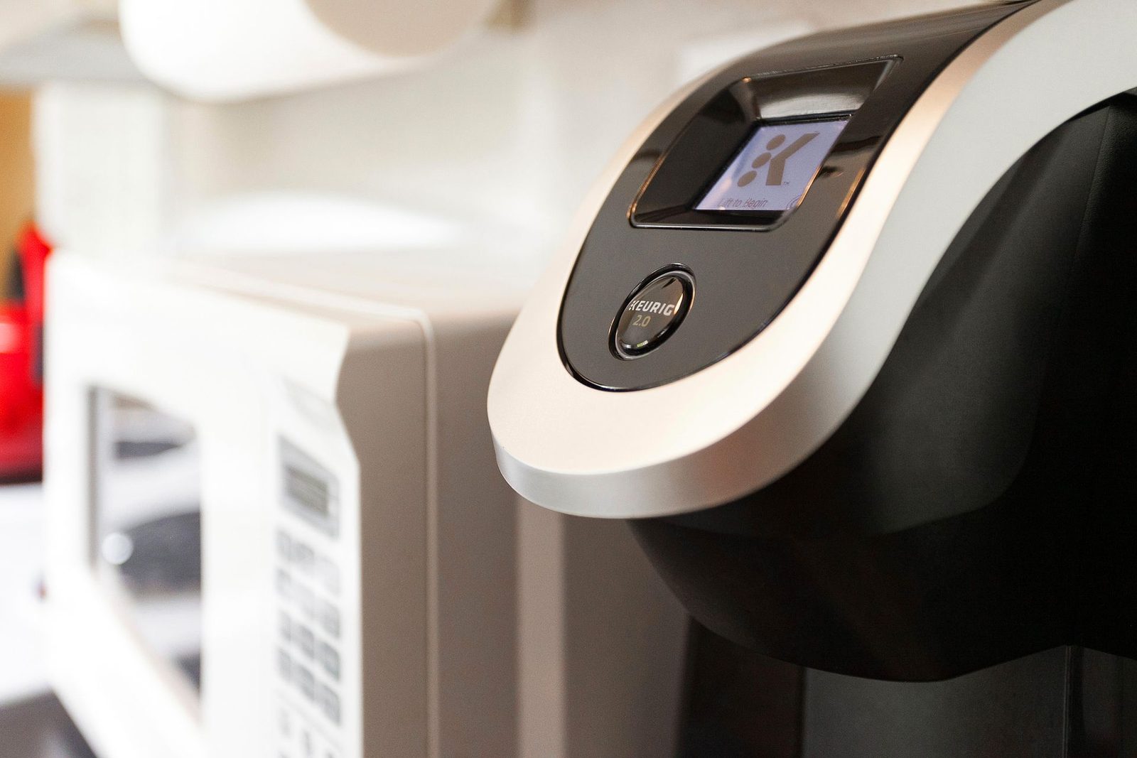 A keurig coffee maker is sitting next to a microwave