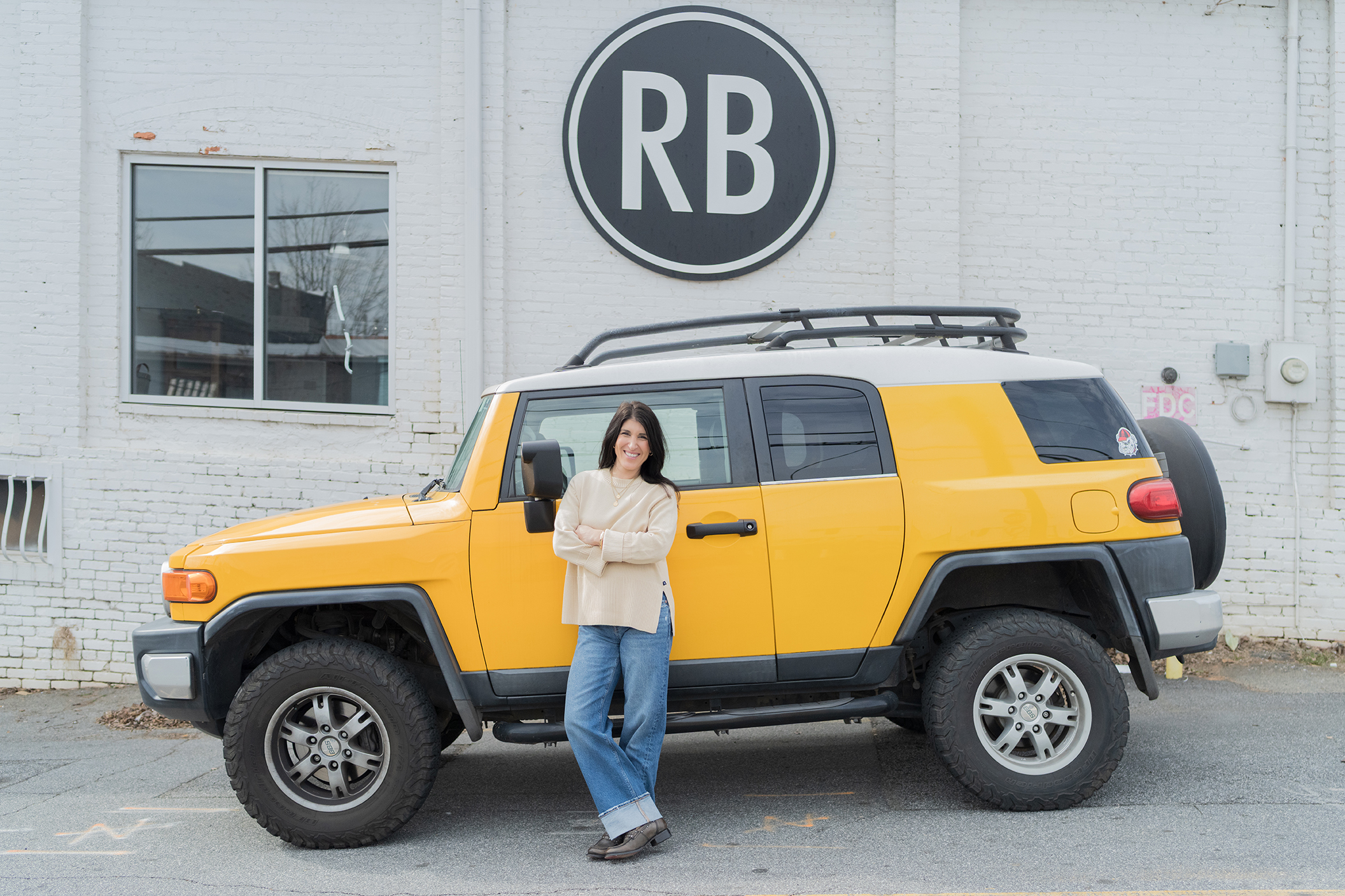 Anita Corsini in front of a yellow SUV
