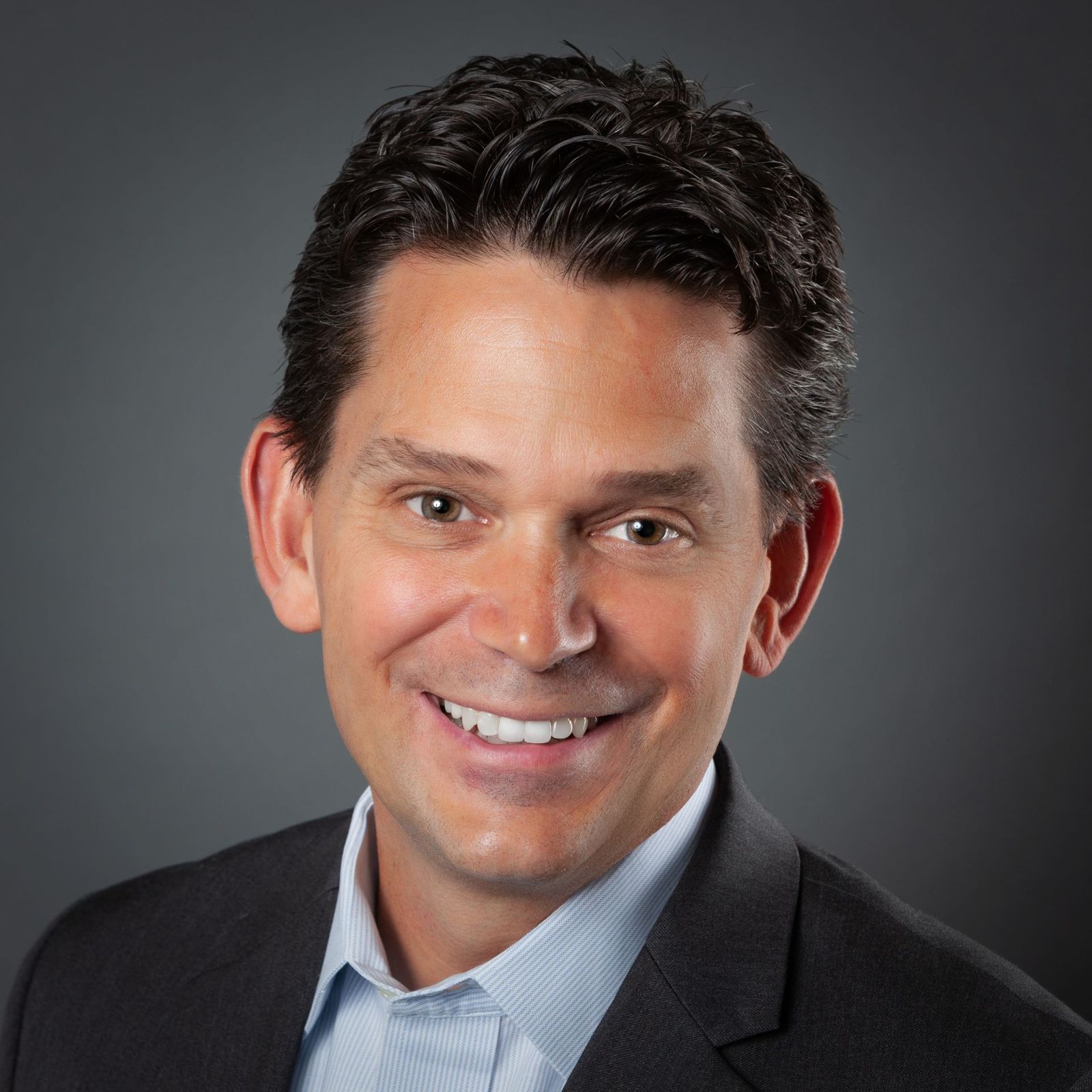 Professional headshot of an agent in a dark blazer