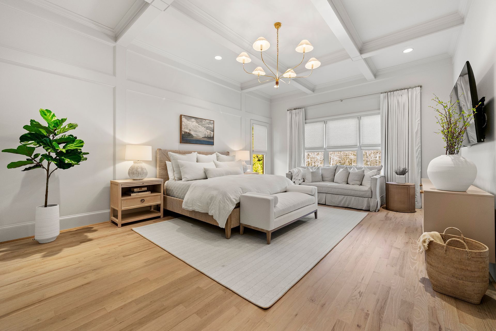 Elegant white bedroom with wooden floors, neutral furniture, and a large window.