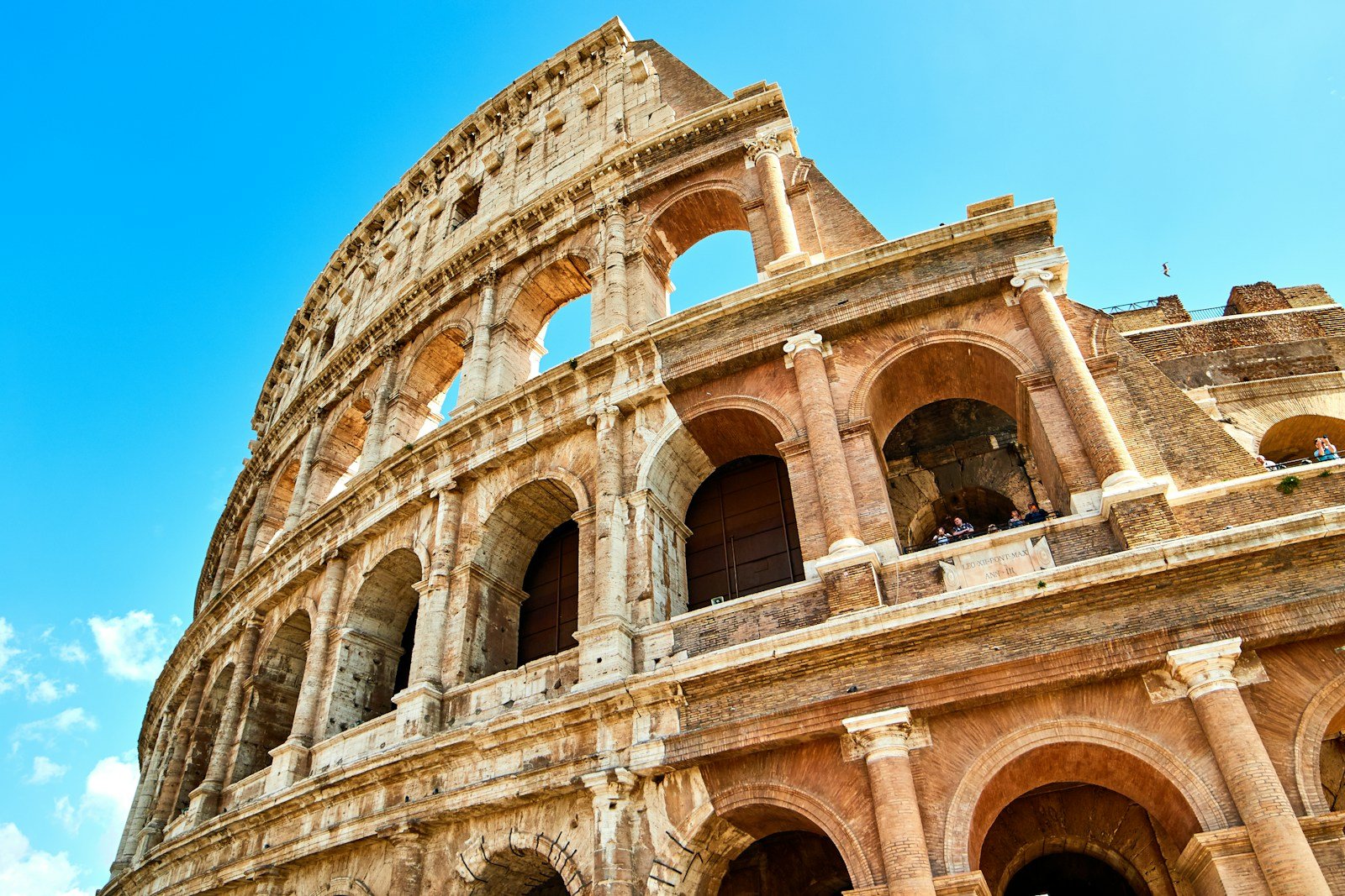 The Colosseum in Rome beneath a blue sky
