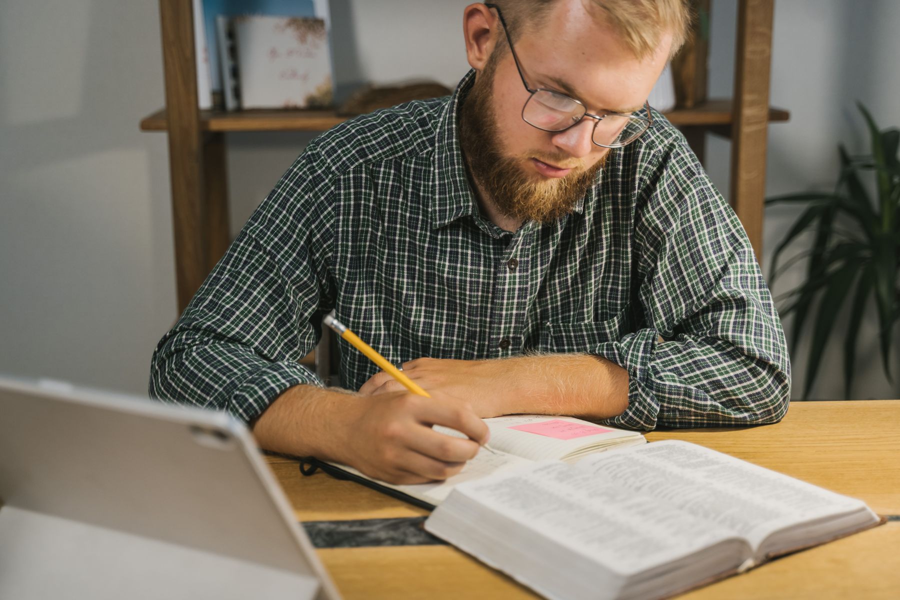 Person taking notes while reading the Bible
