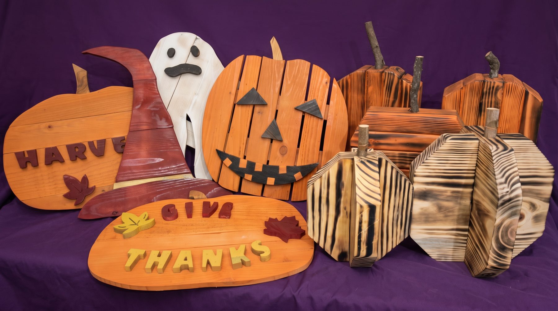 Handmade wooden pumpkins, a ghost, a witch hat, and fall signs