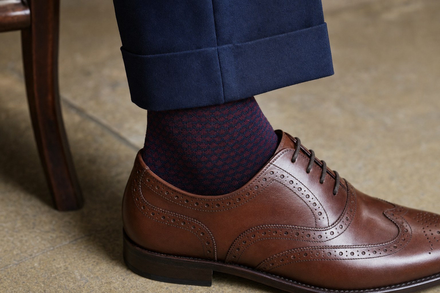 Subtle navy and burgundy patterned dress sock with a navy suit and brown brogue shoe