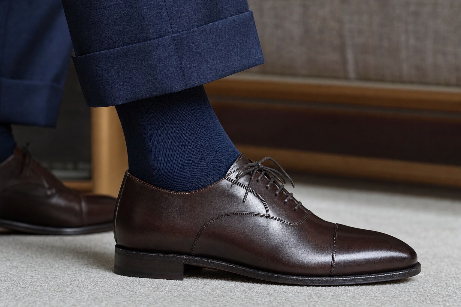 Navy dress sock paired with navy suit trousers and dark brown leather shoes
