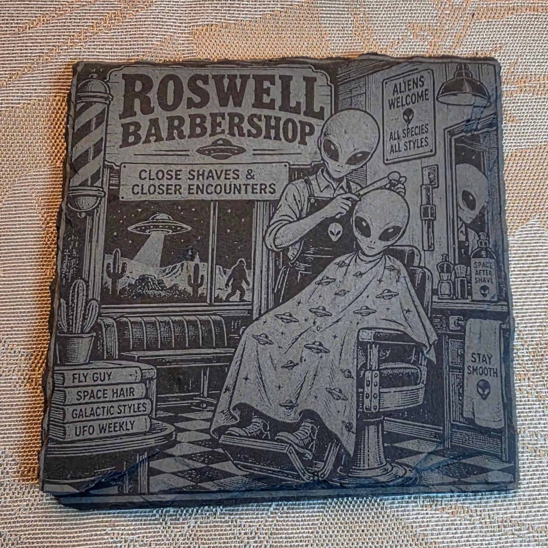 Roswell Barbershop alien slate coaster on a table