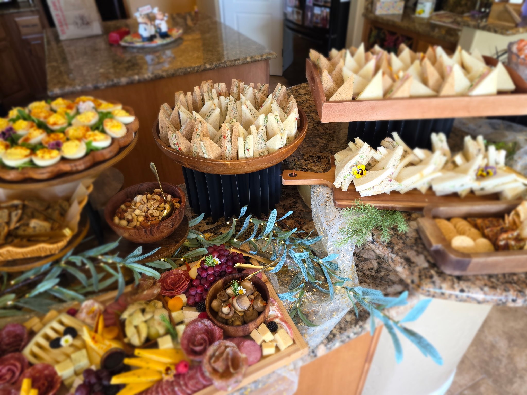 A generous cocktail-hour spread with sandwiches, savory bites, charcuterie, and fresh fruit