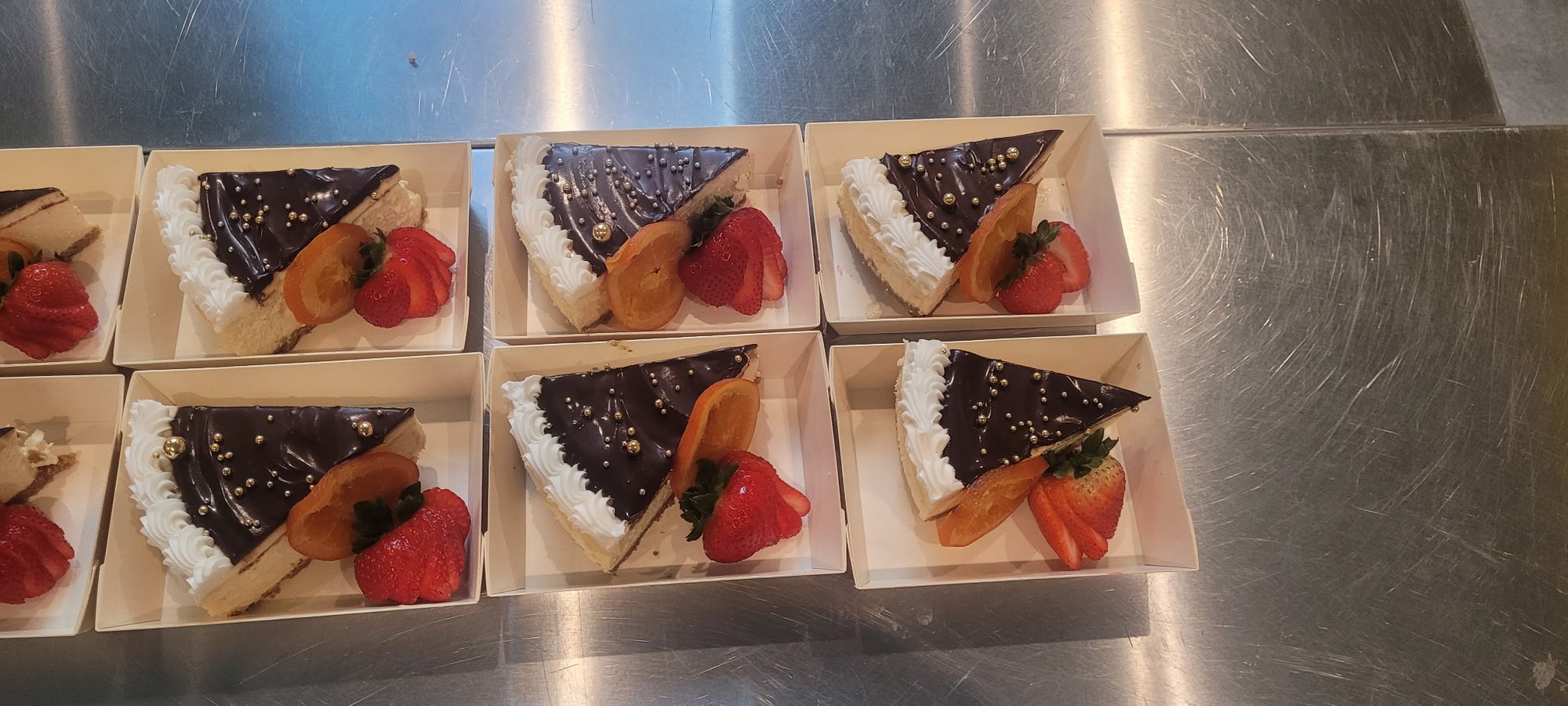 Individual chocolate tarts topped with strawberries on a dessert tray