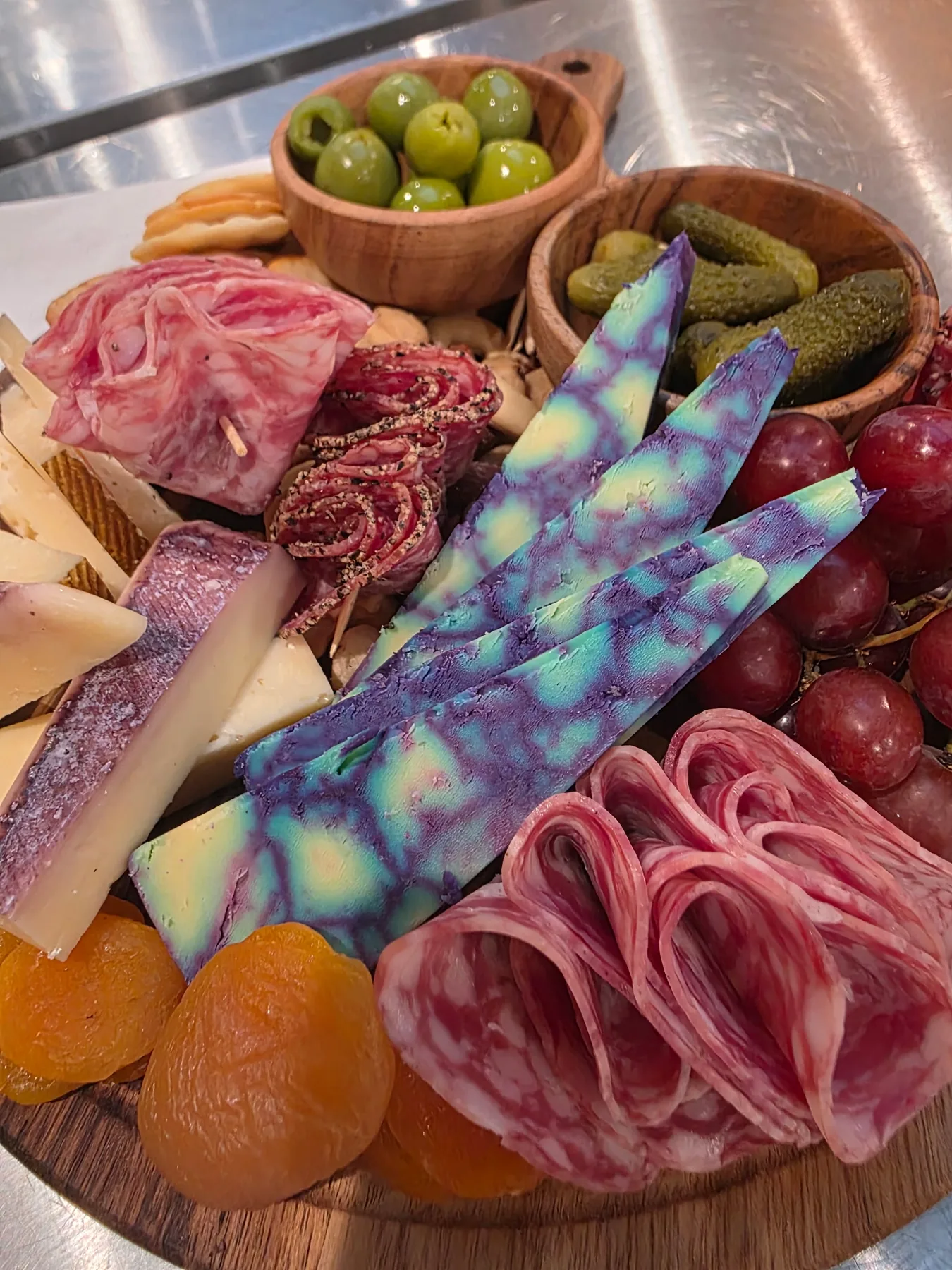 A charcuterie board with folded meats and cheese