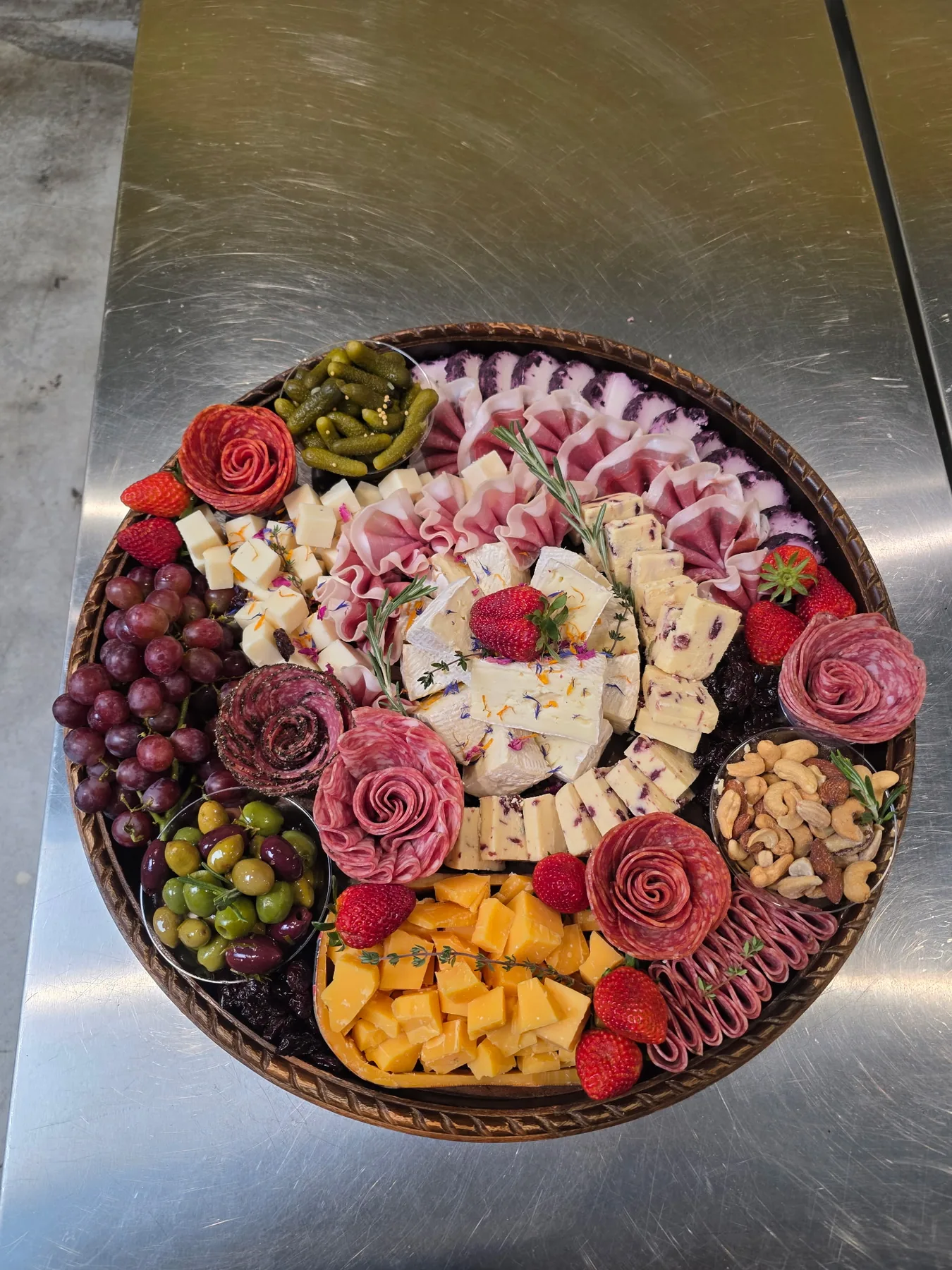 A round charcuterie board with salami roses