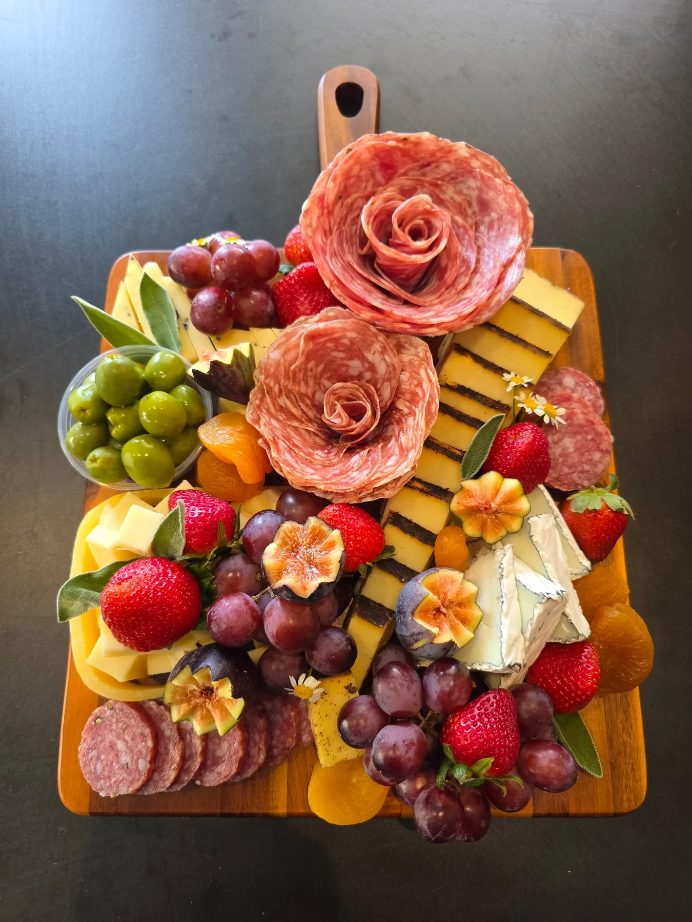 A petite charcuterie board with floral salami roses