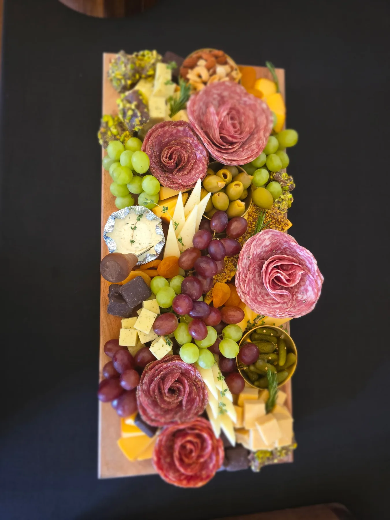 A grazing box styled with fruit, cheese and salami roses