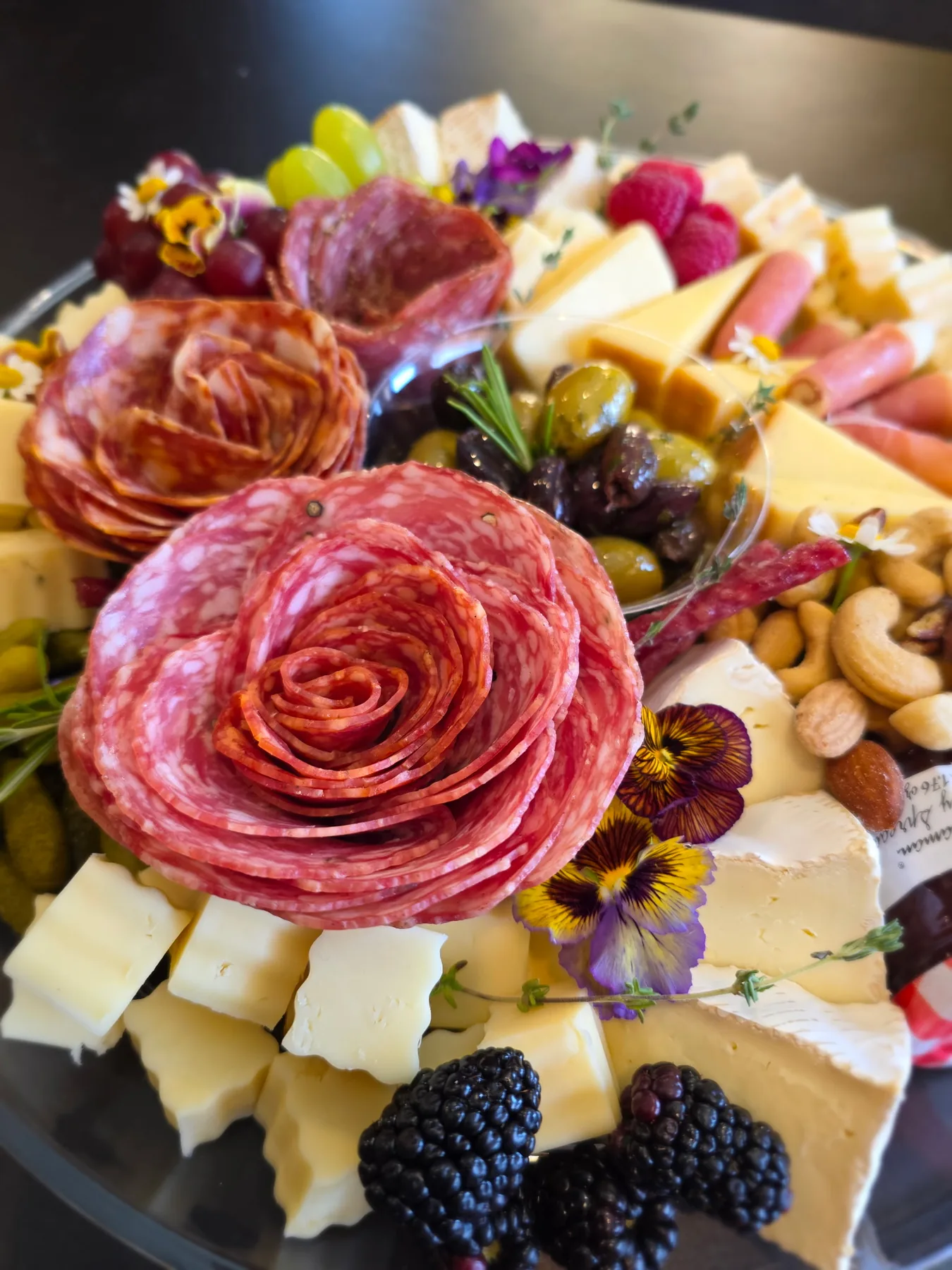 A close-up charcuterie board with a salami rose