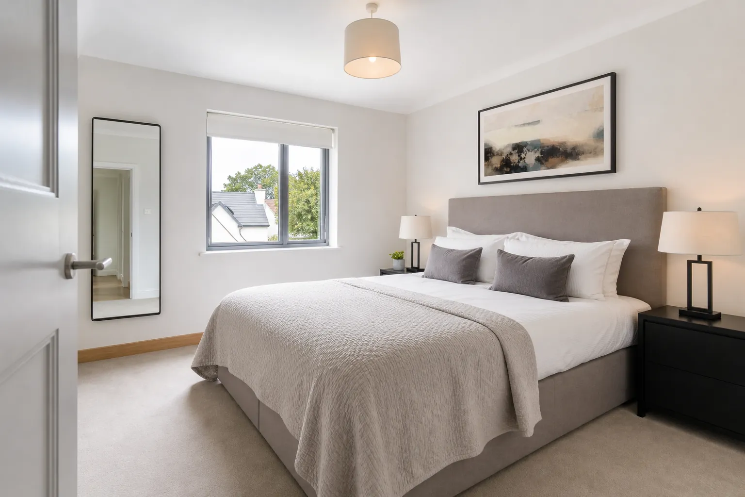 Neatly prepared bedroom with a made bed and clear surfaces