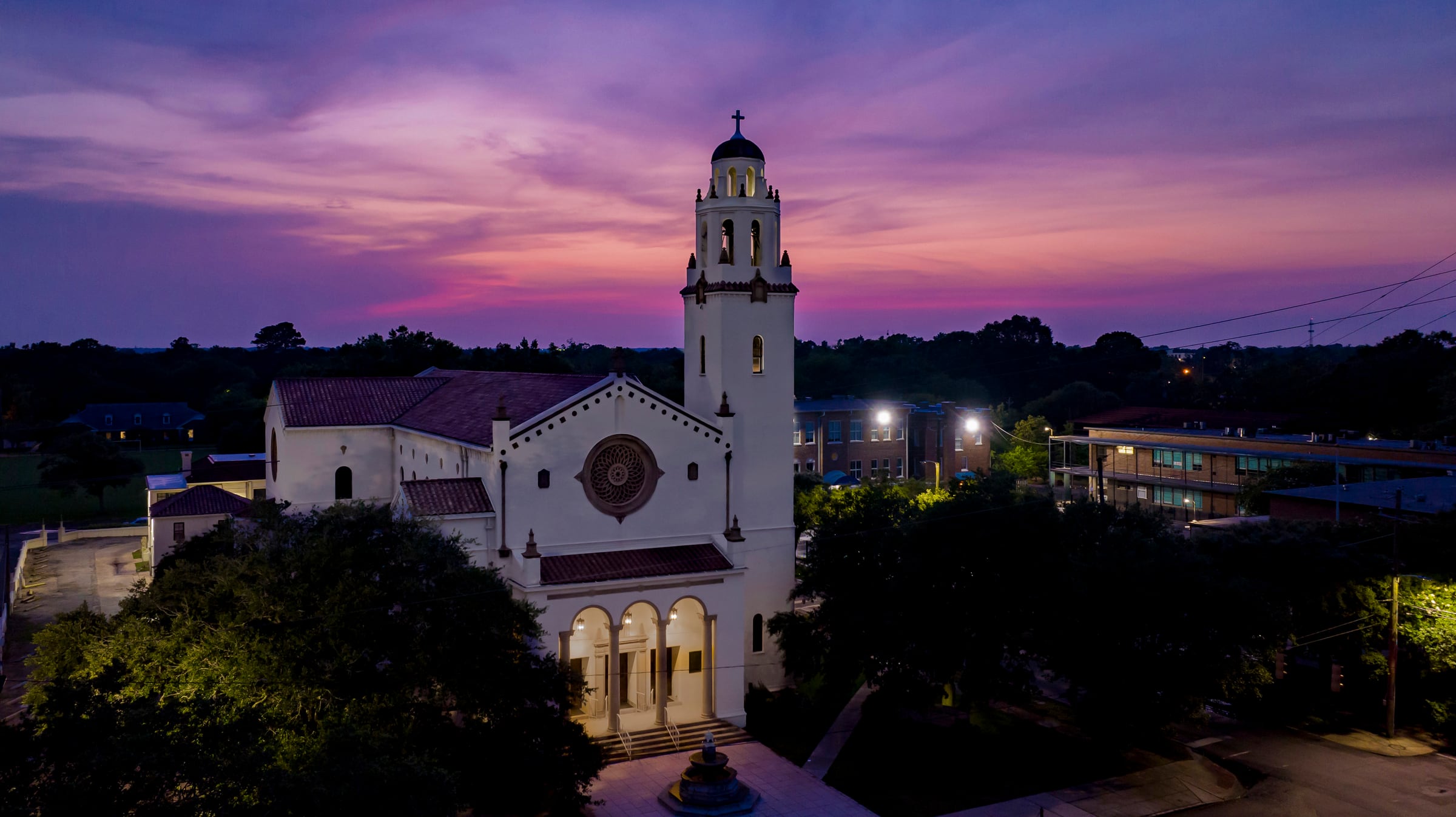 Church illuminated at dusk beneath a purple sky