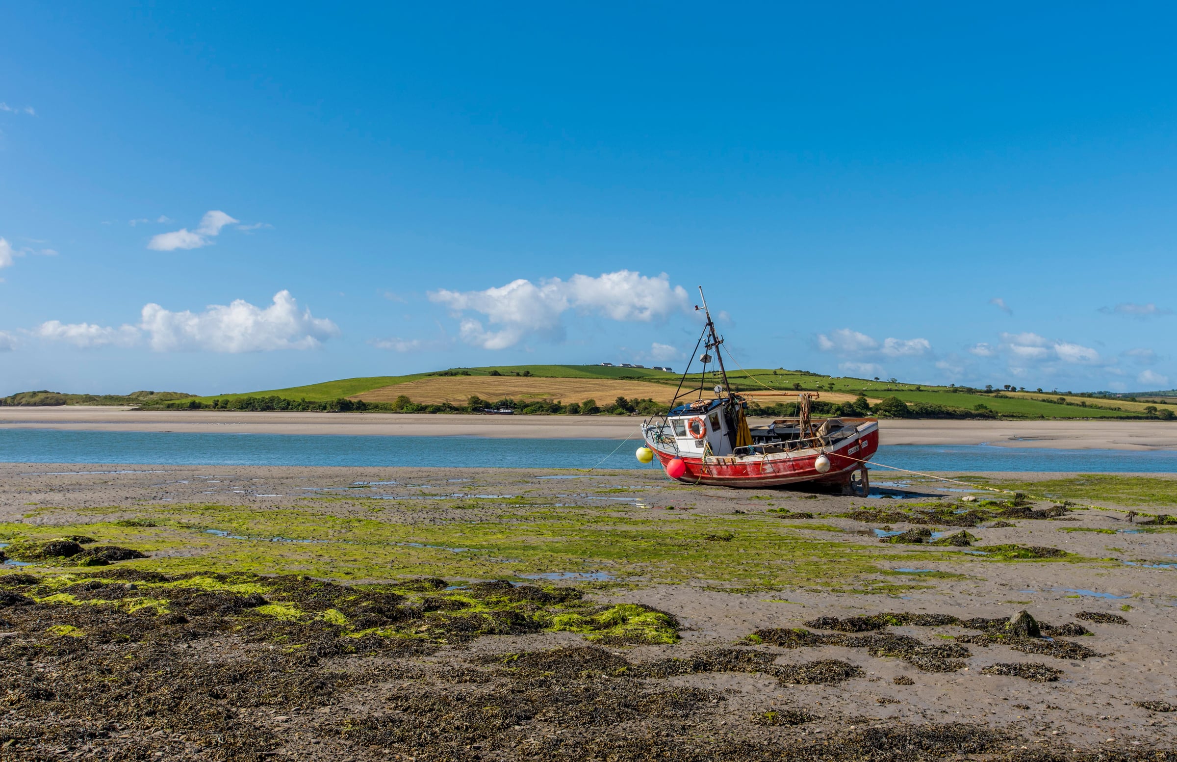 Fishing boat resting on an Irish shore at low tide