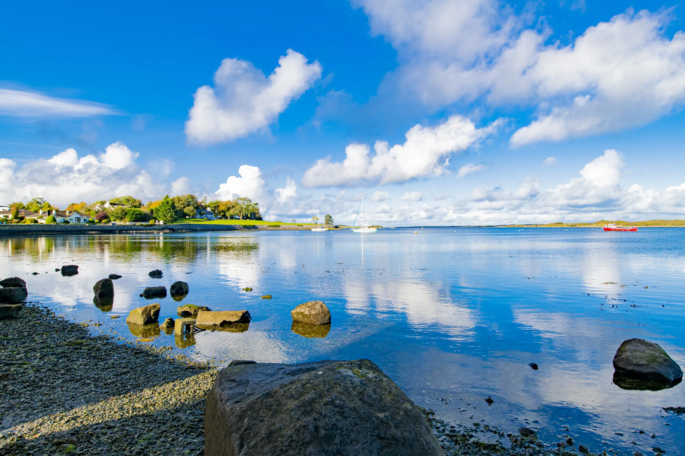 Lakeshore landscape with clouds and clear water