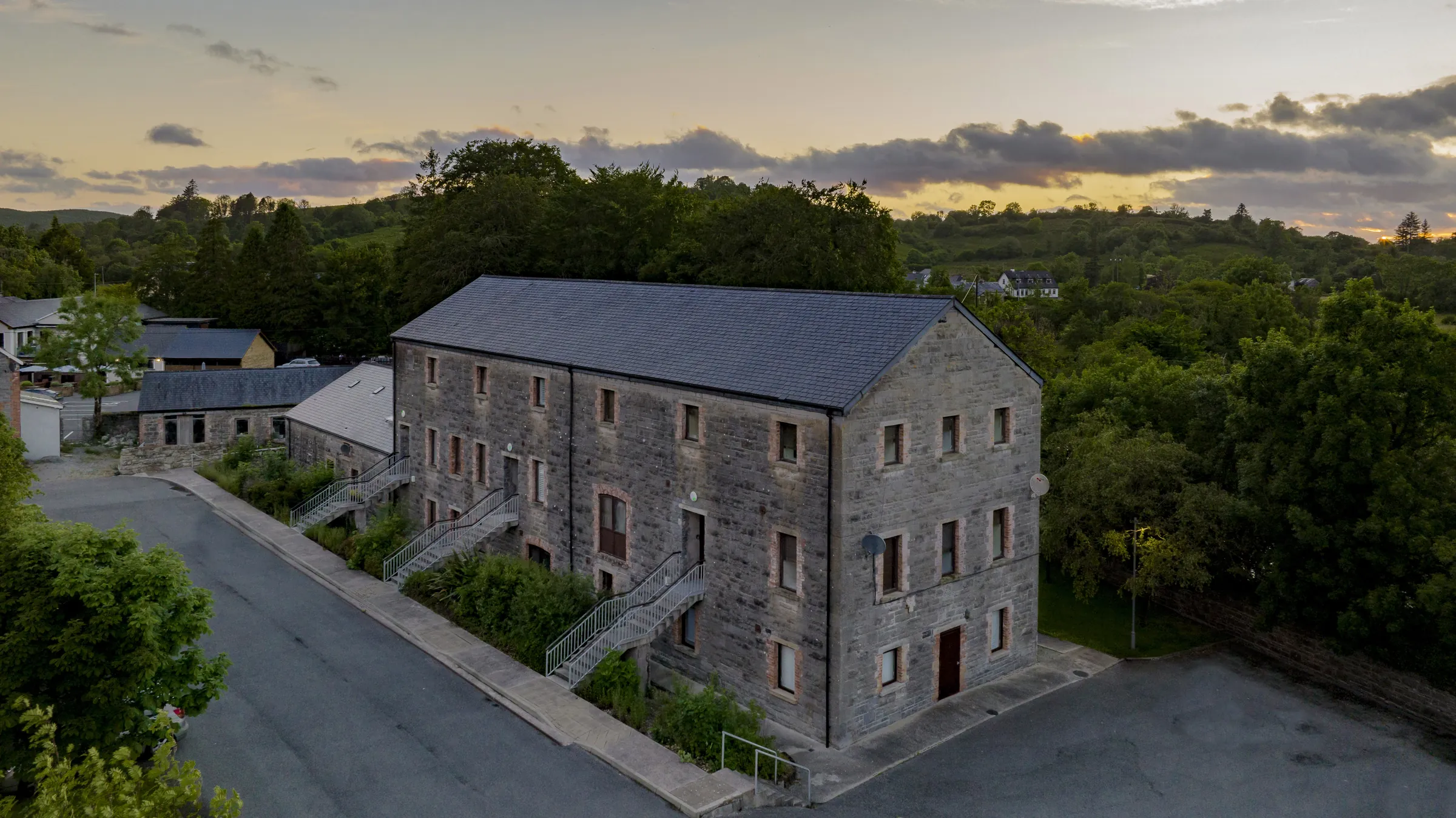 Aerial view of a stone mill building at dusk
