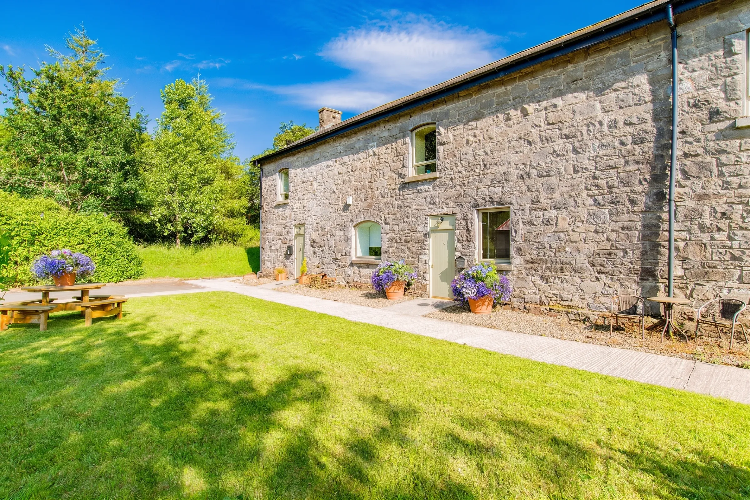 Stone cottage garden with flowering planters