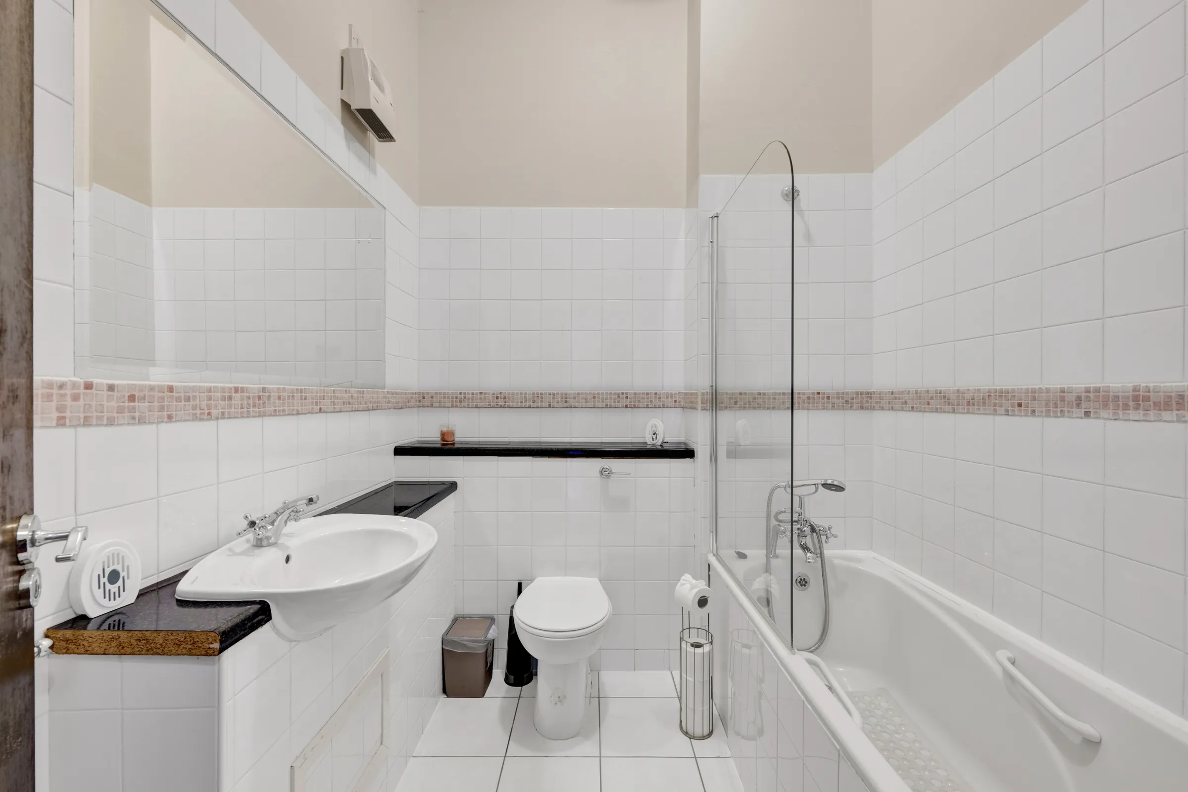 Before virtual renovation: bathroom with white tiled walls and a bathtub