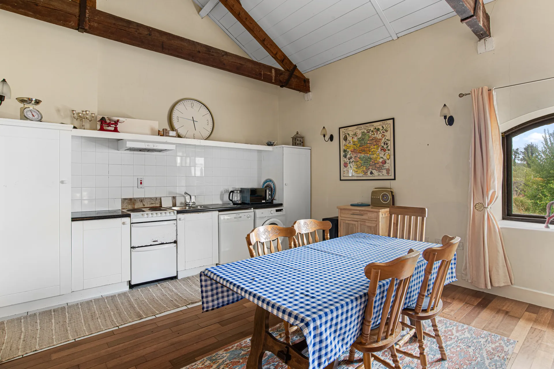 Before virtual renovation: dated kitchen and dining space with exposed timber beams
