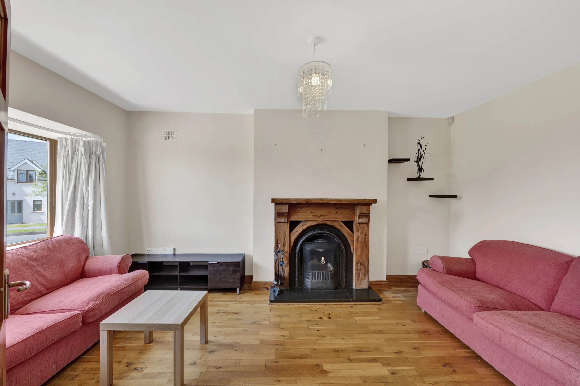Before virtual staging: living room with pink sofas and a fireplace