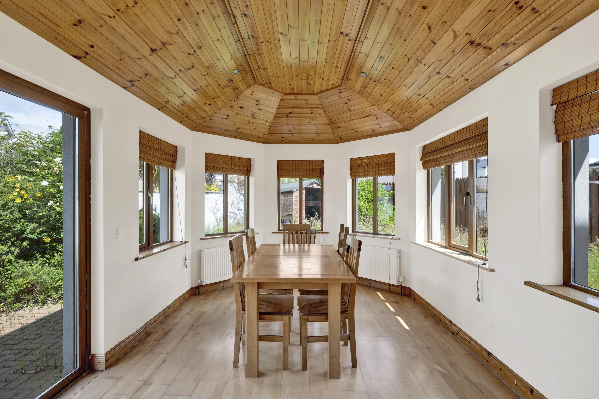 Before virtual staging: an unfurnished sunroom with a dining table