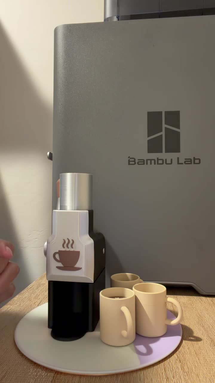 A handmade miniature espresso set displayed in front of a 3D printer