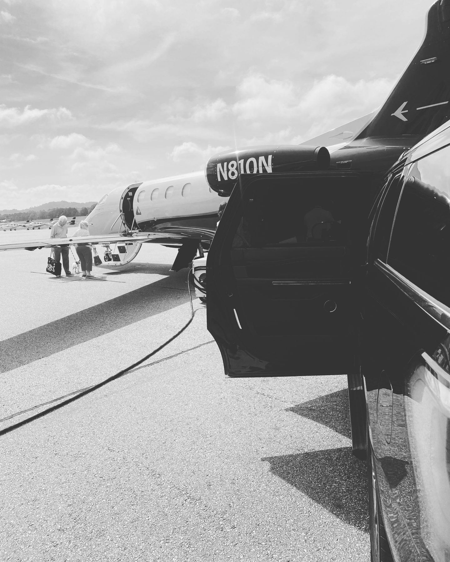 Chauffeured SUV beside a private jet