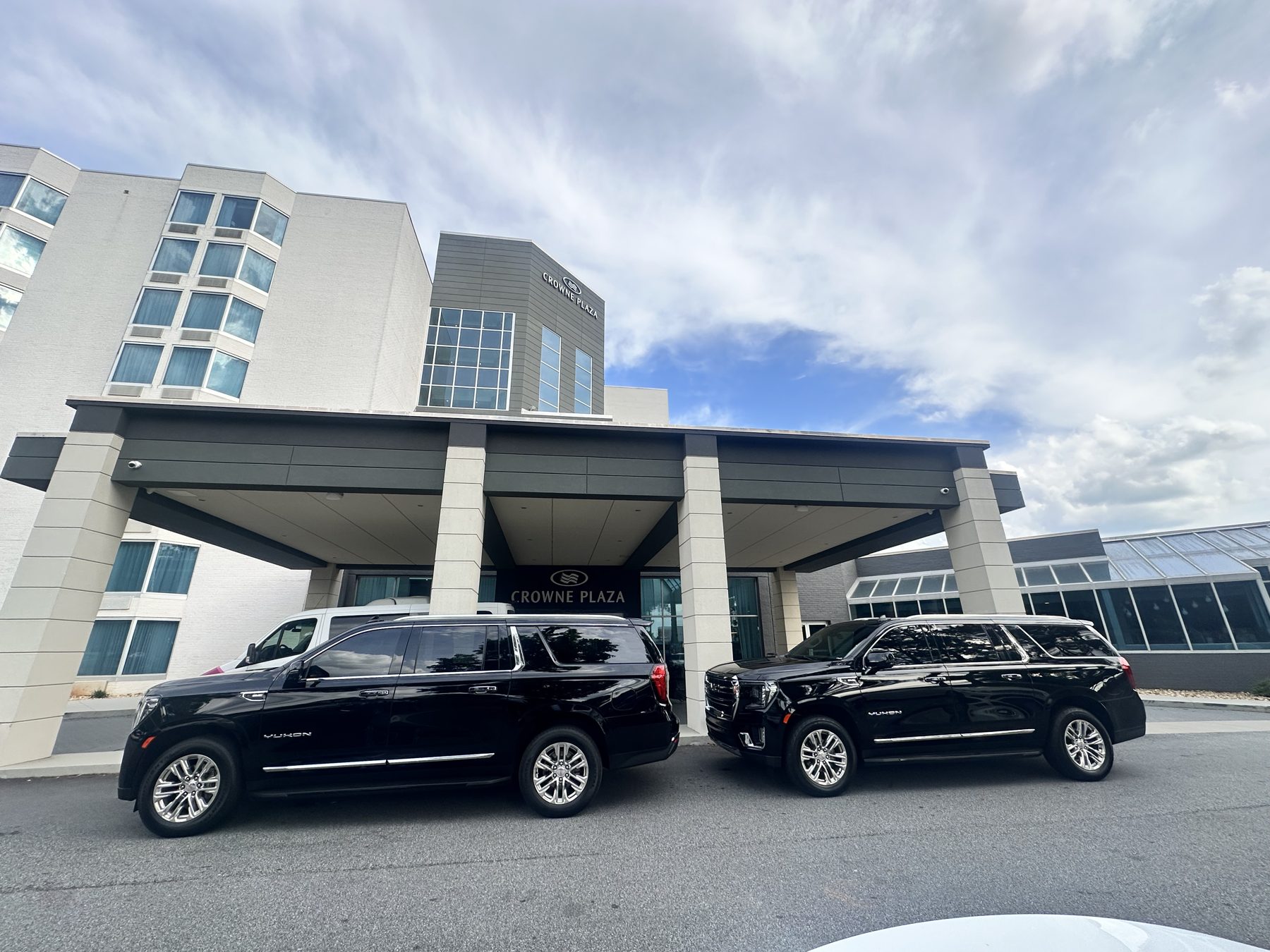 Two black SUVs outside a hotel