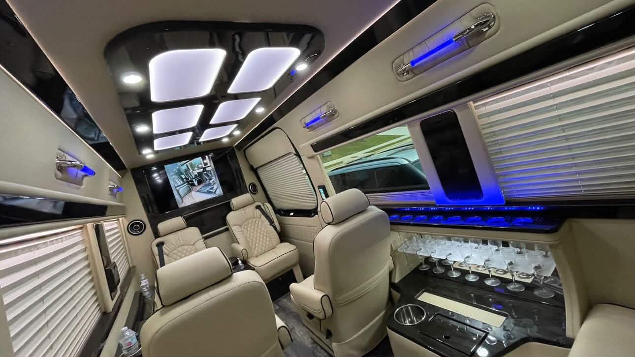 Cream leather seating and overhead lighting inside a Sprinter