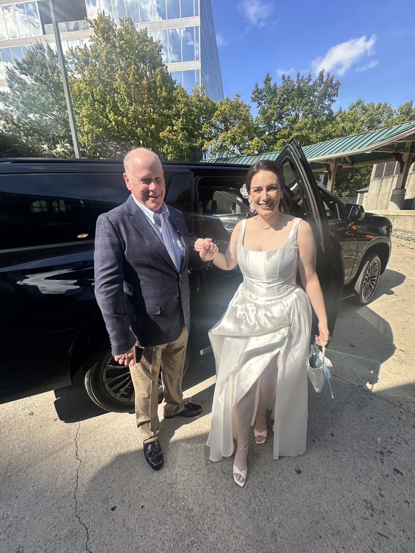 Wedding couple beside a black SUV