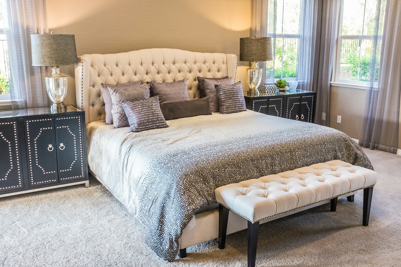 A warmly lit bedroom with a made bed and bedside lamps