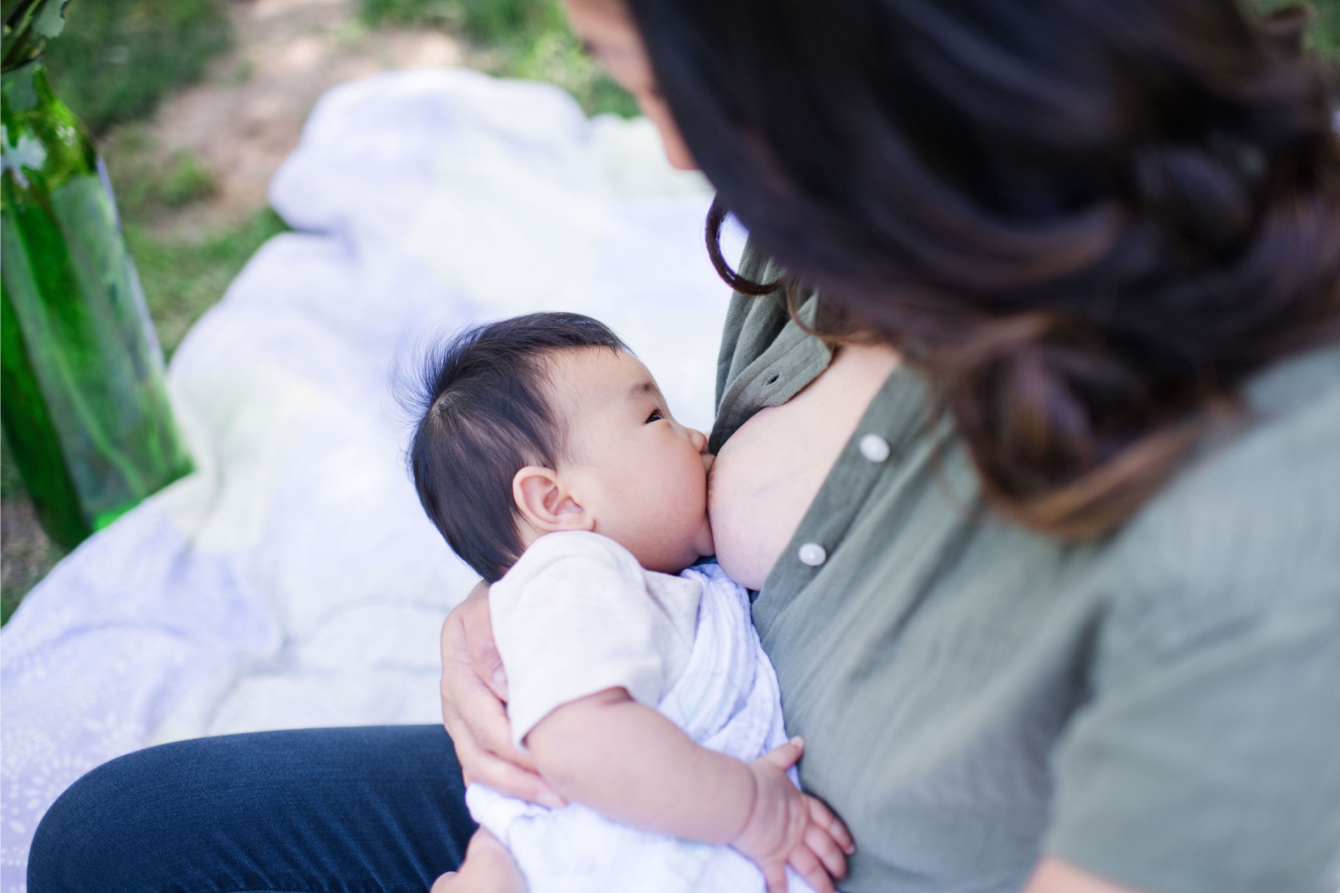 A baby breastfeeding while held by a parent