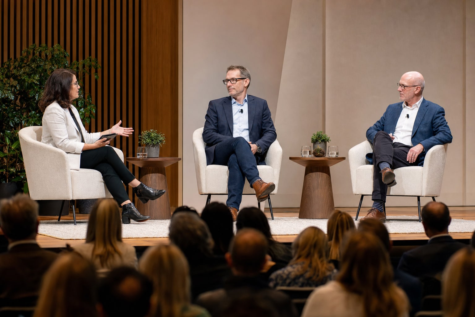 Moderator guiding a business conversation with two guest speakers