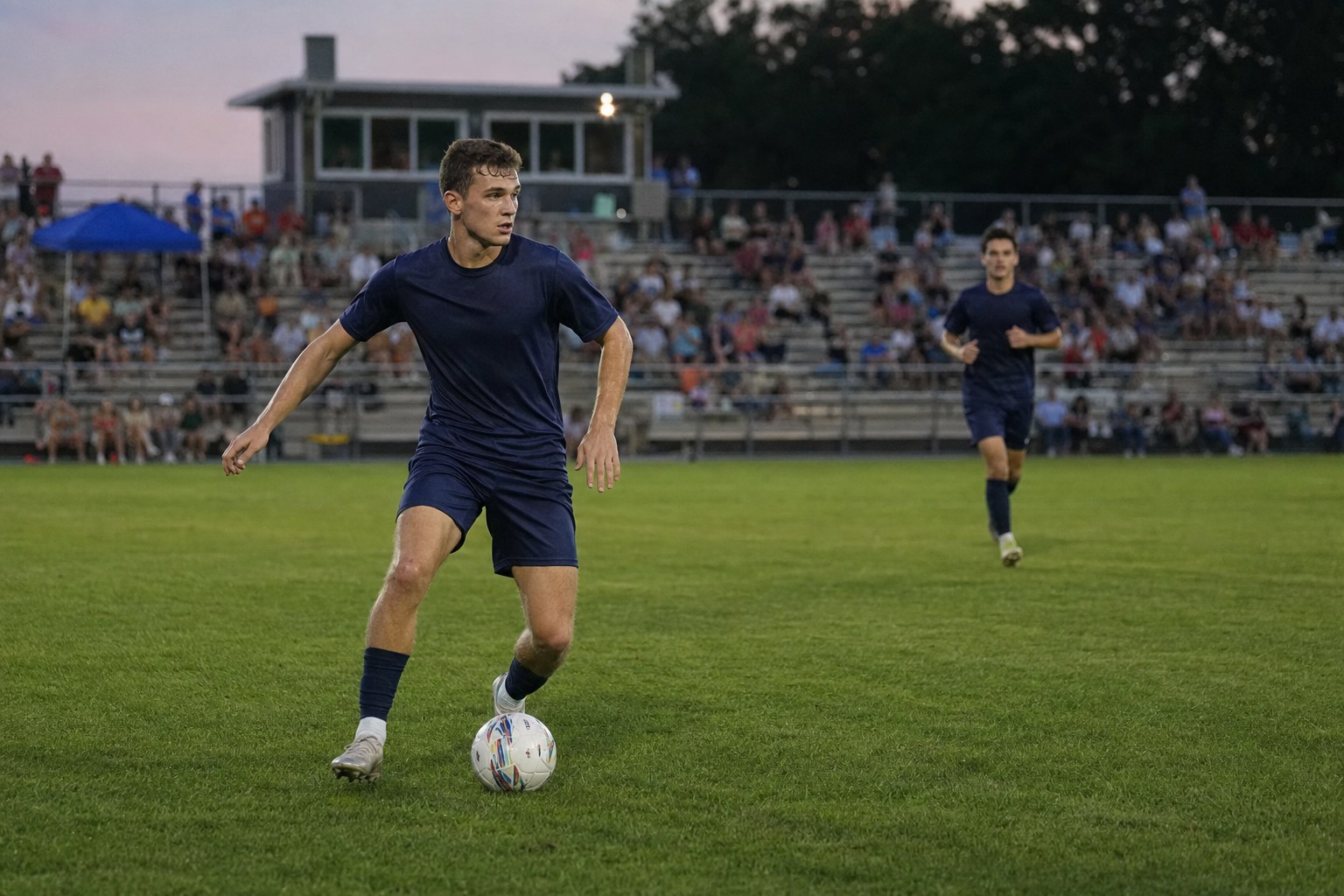 Soccer player controlling the ball during an evening match