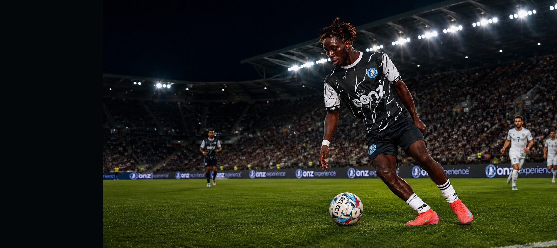 Brooke House FC player in match action under stadium lights