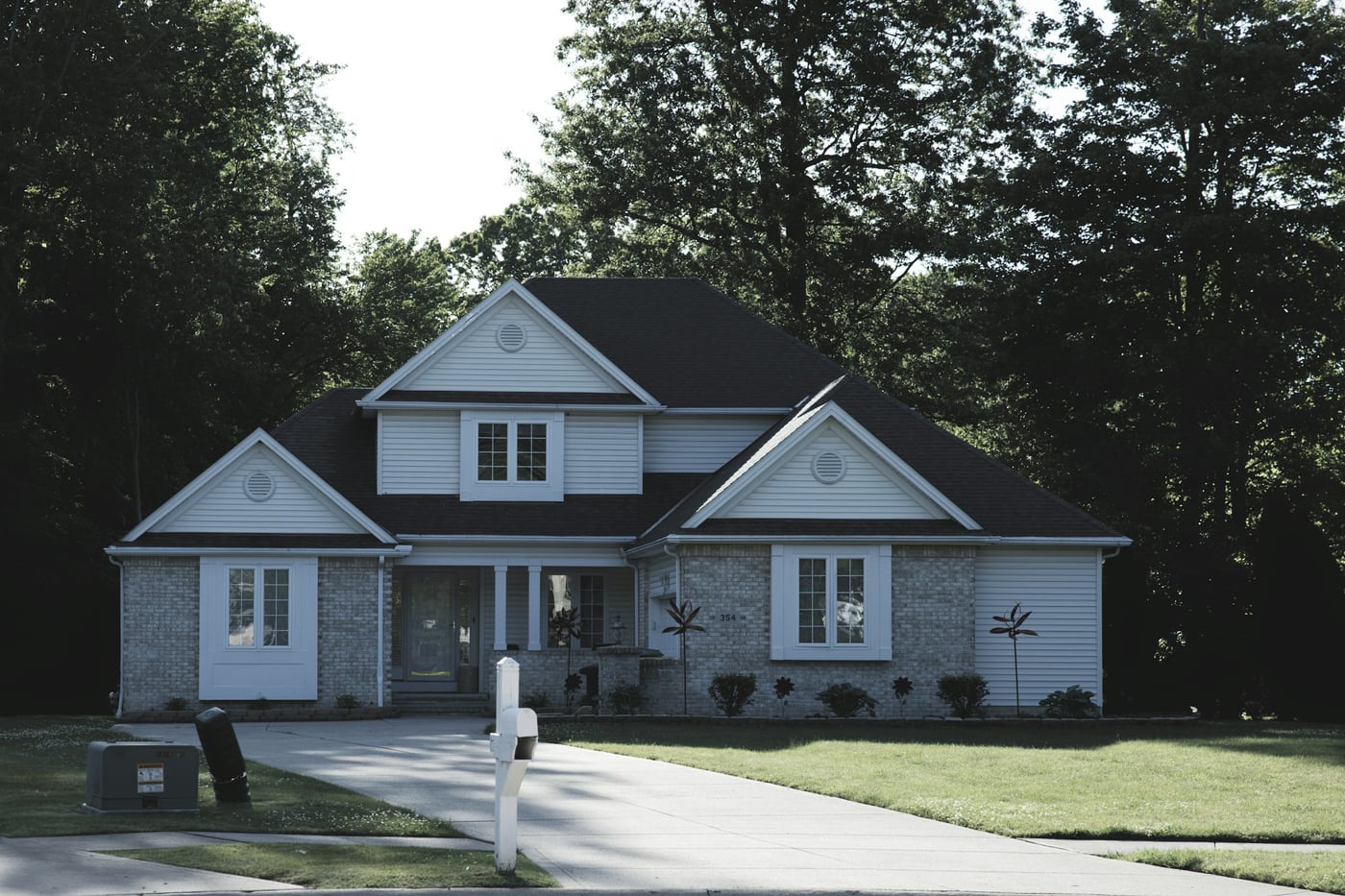 Suburban home with a green lawn and mature trees