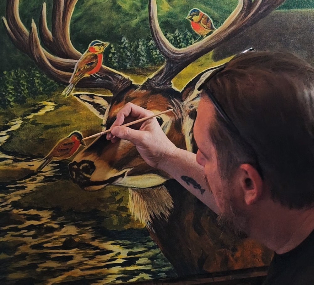 Waylon Christner painting wildlife and birds in his studio