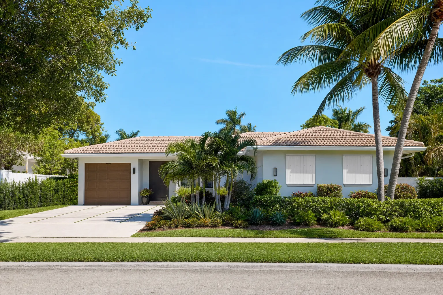 South Florida home with protective shutters and tropical landscaping