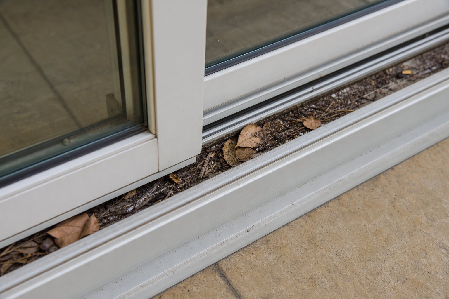 Leaves and debris built up inside a sliding patio door track