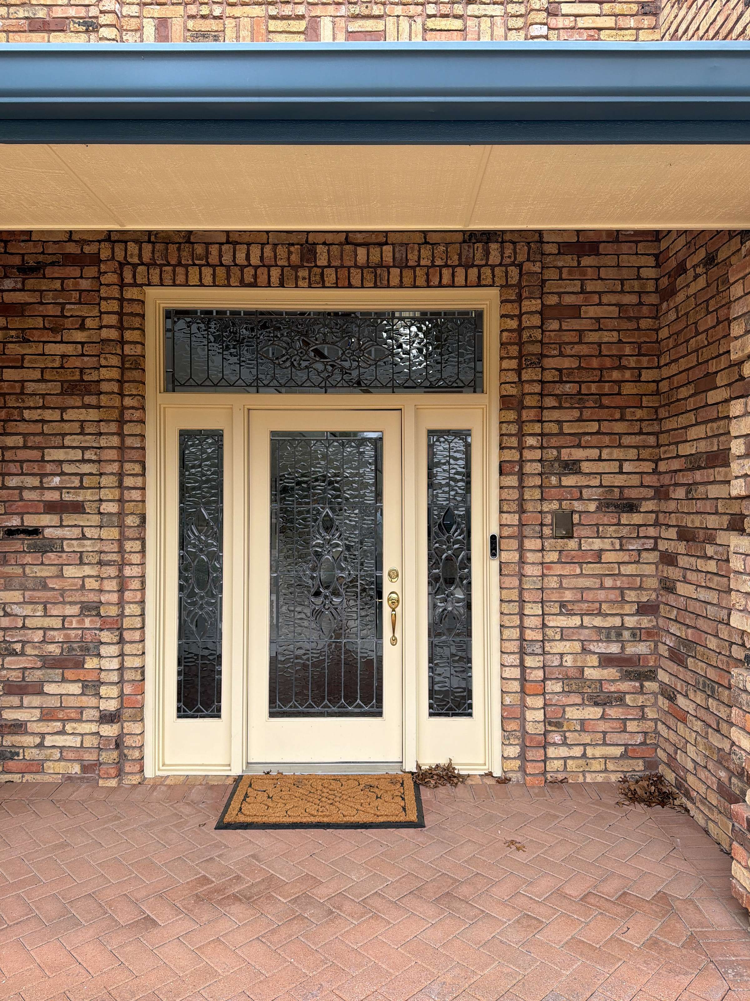 Finished cream French doors at a brick home