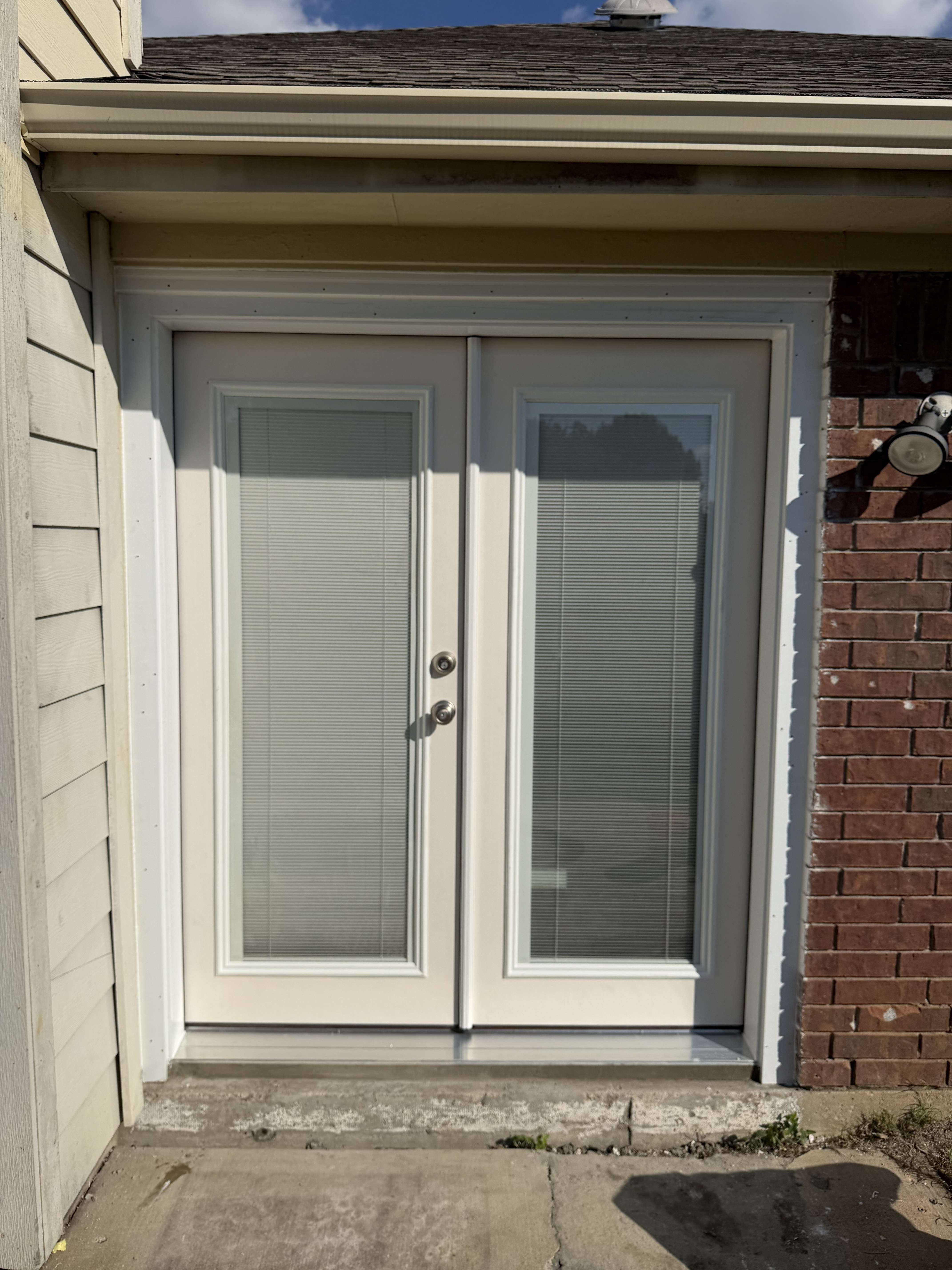 Finished white storm door at a home entrance