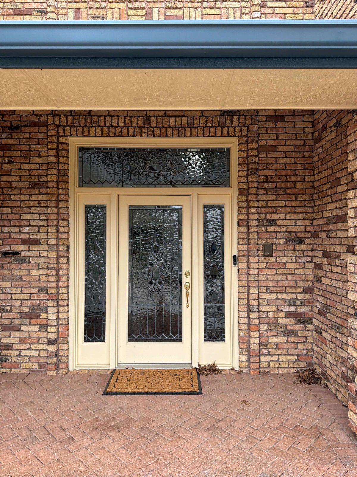 Finished cream French doors at a brick home